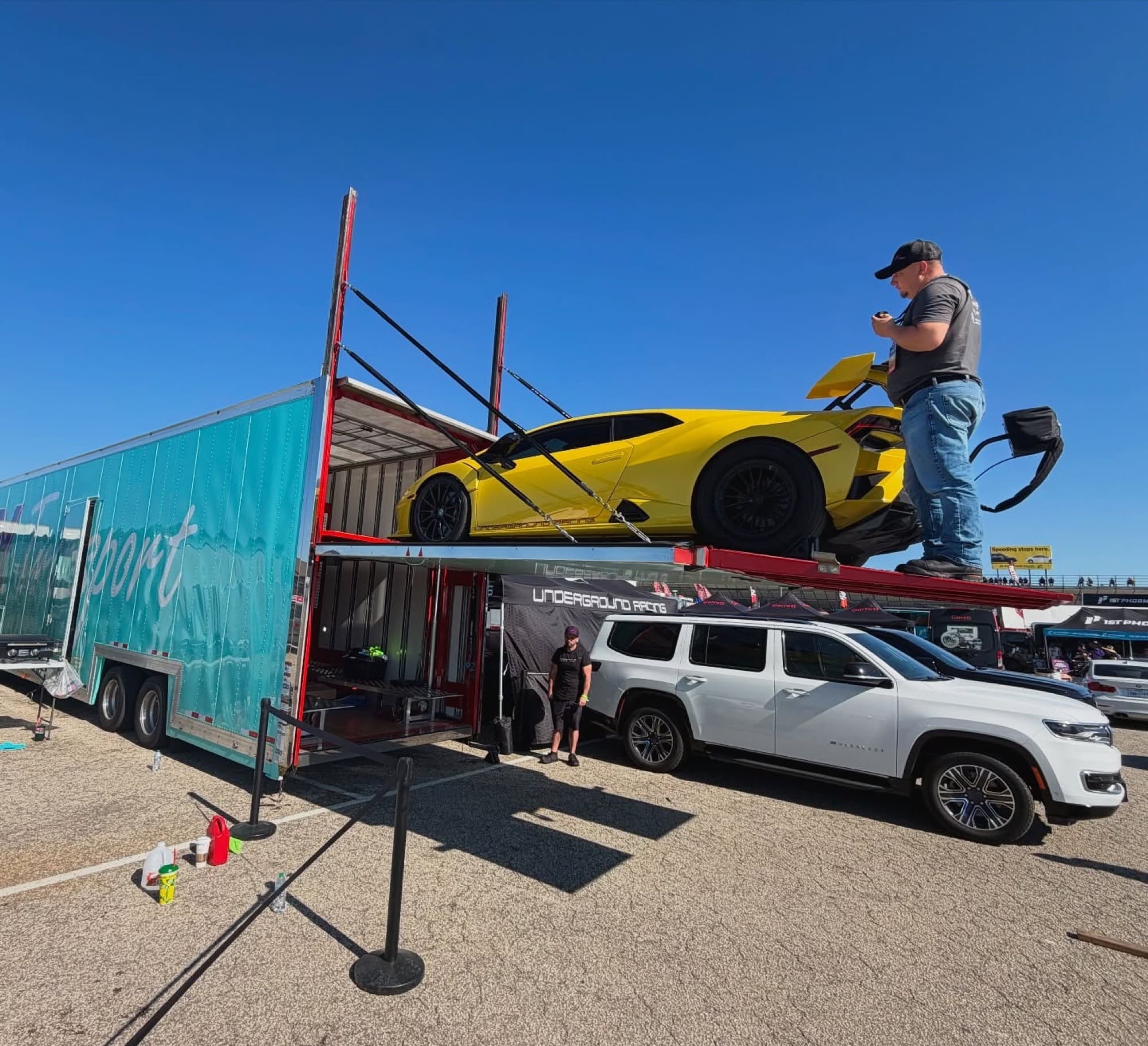 Yellow Lamborghini HuracΓ‘n STO on the VIY trailer liftgate at a track event